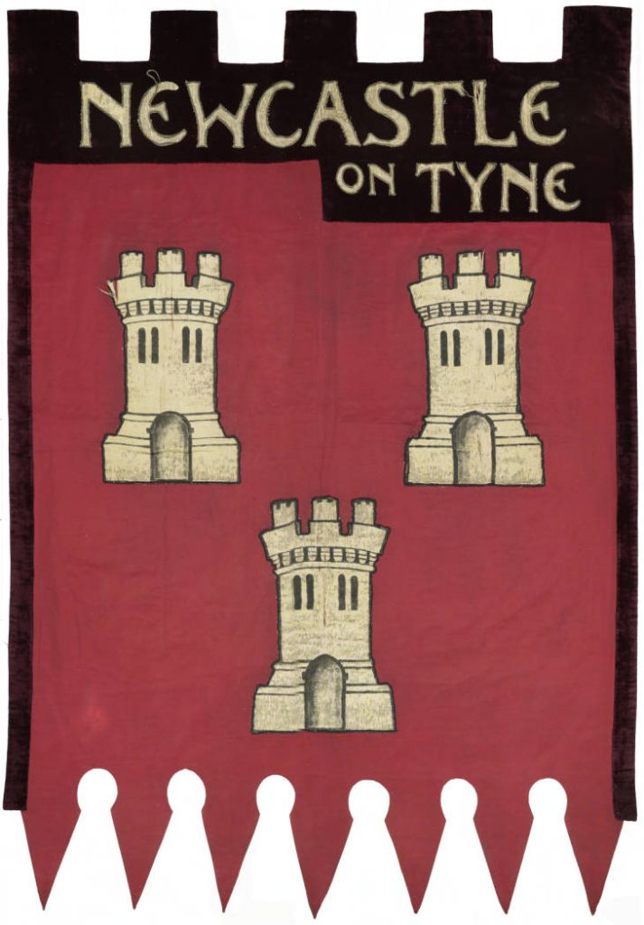 Suffragette Marching banner with 'Newcastle on Tyne' across the top and 3 castles in a reddish background